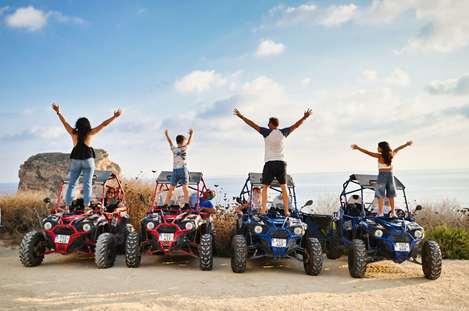 A Family posing on buggies with their backs to the camera, overlooking the sea