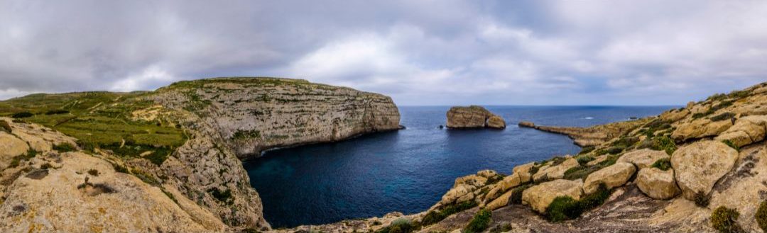 A panoramic view of Dwejra Bay, with Fungus Rock and the Inland Sea on a clear day.