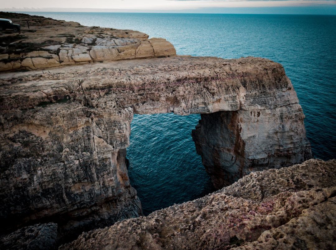 The natural rock arch at Wied il-Mielah, with clear waters in the background.